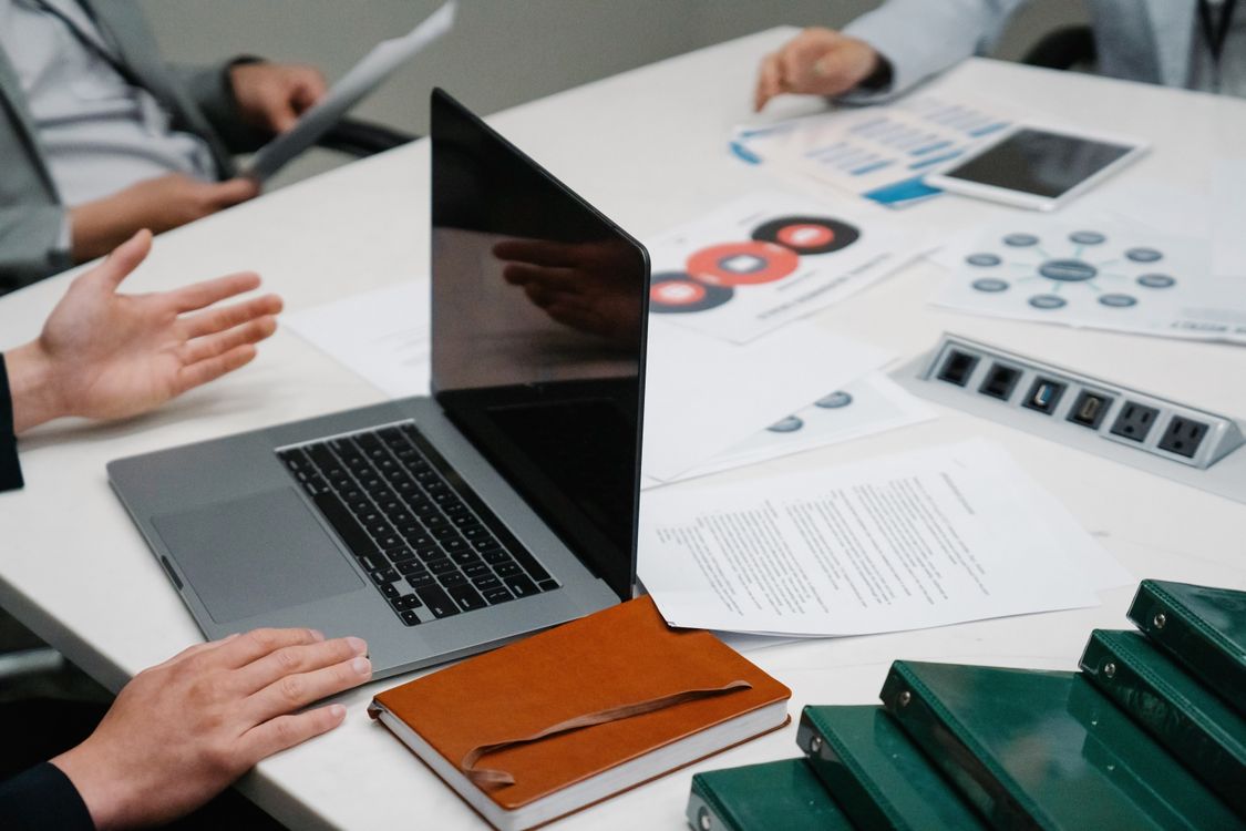 Table with a laptop, documents and planning materials